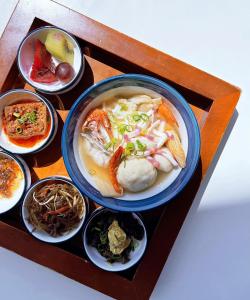 uma mesa com uma tigela de sopa e tigelas de comida em 緩慢大鵬灣 em Donggang