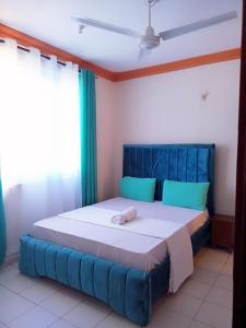 姆瓦帕的住宿－Bliss homestay apartment with swimming pool，一张带蓝色床头板的睡床