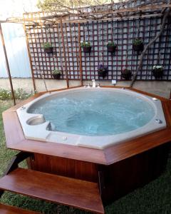 a jacuzzi tub in a backyard with plants at Exclusiva Casa de madera Lunahuana in Lunahuaná
