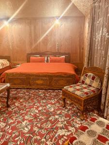ein Schlafzimmer mit einem großen Bett und einem Stuhl in der Unterkunft Houseboat Kashmir Treat in Srinagar