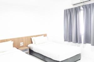 1 dormitorio con 2 camas y ventana en Patong Bay Inn, en Patong Beach