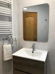 ein Bad mit einem Waschbecken und einem Spiegel in der Unterkunft Piso céntrico cerca de la playa in A Coruña