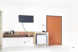 een keuken met een tv en een kleine koelkast bij Patong Bay Inn in Patong Beach