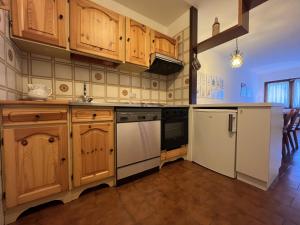 een keuken met houten kasten en witte apparaten bij Appartamenti Doss in Giustino