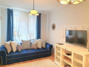 a living room with a blue couch and a tv at Apartament Trzy Sypialnie Stare Miasto in Elblag