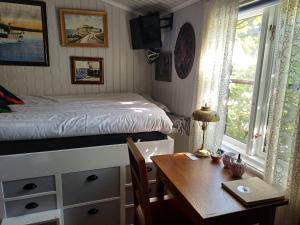 sypialnia z biurkiem, łóżkiem i stołem w obiekcie Flodhästens Husrum & Frukost w mieście Varberg