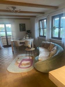 a living room with a couch and a table at Idyllische Ferienwohnungen in Mossendorf Blick zur Naab in Burglengenfeld