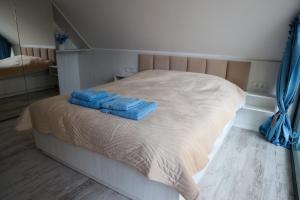 a bed with two blue towels on top of it at Mazurskie Niebo Apartamenty in Gołdap