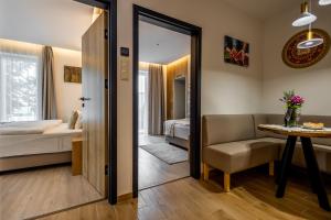 a bedroom with a bed and a table and a mirror at Mokka House Panzió in Miskolc