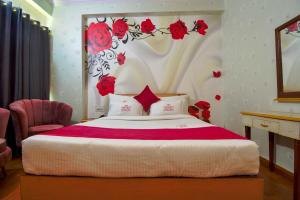 een slaapkamer met een bed met rode rozen aan de muur bij Hotel Parv in Jaipur