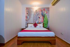 1 dormitorio con 1 cama con una pintura en la pared en Hotel Parv en Jaipur