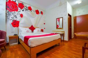 una camera da letto con un letto con rose rosse sul muro di Hotel Parv a Jaipur