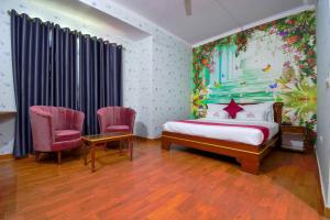 a bedroom with a bed and two chairs at Hotel Parv in Jaipur