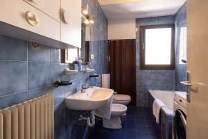 bagno blu con lavandino e servizi igienici di Stay'n Go Appartment a Bolzano