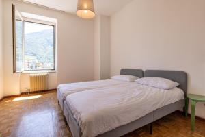 una camera da letto con un letto e una grande finestra di Stay'n Go Appartment a Bolzano