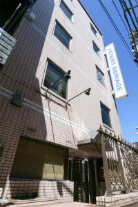 un bâtiment avec une enseigne sur le côté dans l'établissement J-Court Oshiage, à Tokyo