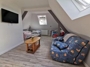 a living room with a couch and a tv at Les Logis de Catherine et Serge in Genêts