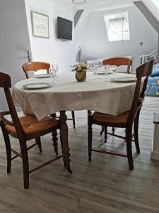 une table à manger avec des chaises et un tissu de table blanc dans l'établissement Catherine et Serge, à Genêts