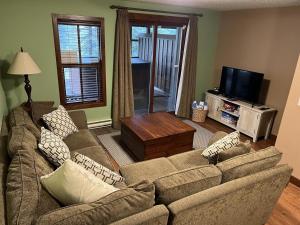 uma sala de estar com dois sofás e uma televisão em Trappers Landing #34 by Bear Country em Sun Peaks