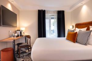 パリにあるホテル シャヴァネルのベッドとデスクが備わるホテルルームです。