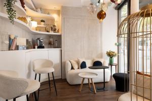 - un salon avec un canapé, une table et des chaises dans l'établissement Hotel Chavanel, à Paris