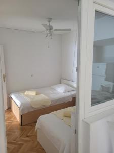 a small room with two beds and a mirror at Apartments Nina in Sutivan