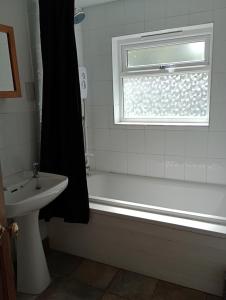 a bathroom with a tub and a sink and a window at Bellevue cottage in Wicken +14 photos