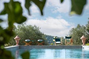 una piscina con 2 sillas y una mesa en Casavilla Rentals by Torre a Cona en Rignano sullʼArno