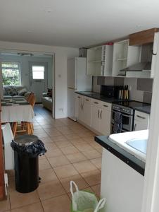 cocina con electrodomésticos blancos y sala de estar. en Bellevue cottage en Wicken