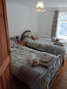1 dormitorio con 2 camas con animales de peluche en Bellevue cottage en Wicken