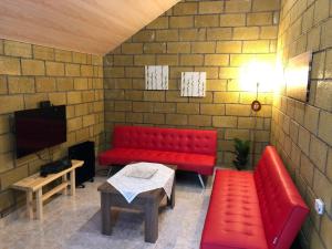 een rode bank en een tafel in een kamer bij Tranquil Forest Retreat cozy Cottage near Sevan in Sevan