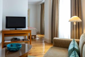 sala de estar con TV y sofá en Tomtom Suites en Estambul