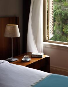 a bedroom with a bed and a table with a lamp and a window at Tomtom Suites in Istanbul