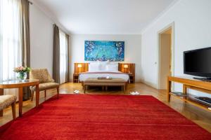 イスタンブールにあるトムトム スイーツのベッドと赤い敷物が備わるホテルルームです。