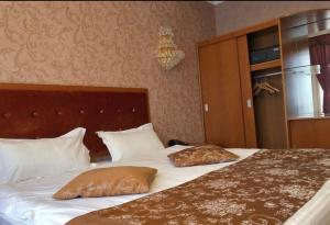 1 dormitorio con 1 cama con 2 almohadas en Royal_hotel_hostel, en Aktobe