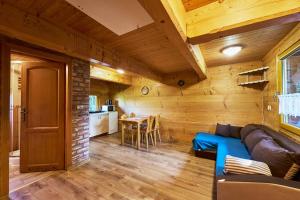 Una sala de estar con un sofá azul y una mesa. en Domek Kołodziejówka Polanica Zdrój, en Polanica-Zdrój