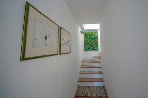 um corredor com duas fotografias na parede e uma escada em Agriturismo La valle em Peccioli