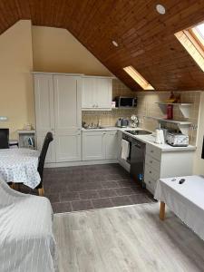 una cocina con armarios blancos y una mesa en una habitación en Kylemore Lakeview Retreat en Blessington