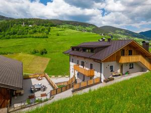 an aerial view of a house in a green field at Planerhof Apartment Alpenrose in Funes