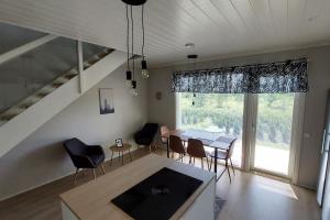 een woonkamer met een eettafel en stoelen bij Kotimaailma Apartments Sääksmäentie in Jyväskylä