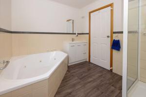 łazienka z dużą wanną i umywalką w obiekcie Kitty's Cottages - Managed by BIG4 Strahan Holiday Retreat w mieście Strahan