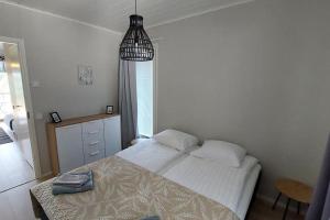 1 dormitorio con 1 cama y luz colgante en Kotimaailma Apartments Sääksmäentie, en Jyväskylä