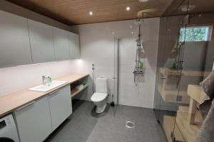 a bathroom with a shower and a toilet and a sink at Kotimaailma Apartments Sääksmäentie in Jyväskylä