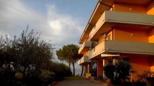 un edificio naranja con un árbol al lado en Albergo Il Biancospino en Sirmione