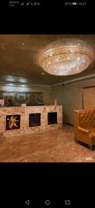 a large room with a couch and a chandelier at Royal_hotel_hostel in Aktobe