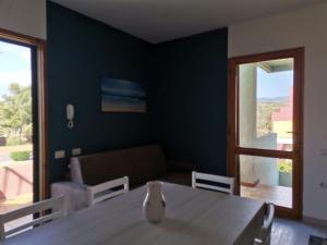 a dining room with a table and a couch at Santa Luria Casa dolce Casa in Santa Luria