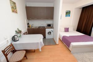 a small room with a table and a bed and a kitchen at Aparthotel Almarent in Almaty