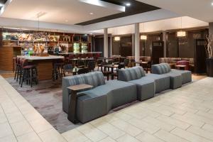 um restaurante com sofás e mesas e um bar em Courtyard by Marriott Augusta em Augusta