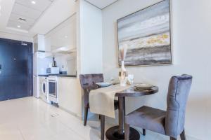 a dining room with a table and chairs in a kitchen at Cozy Haven Studio in Dubai