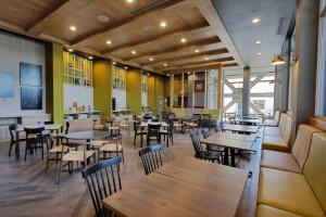 a restaurant with wooden tables and chairs and yellow walls at Fairfield Inn & Suites by Marriott Mexicali in Mexicali
